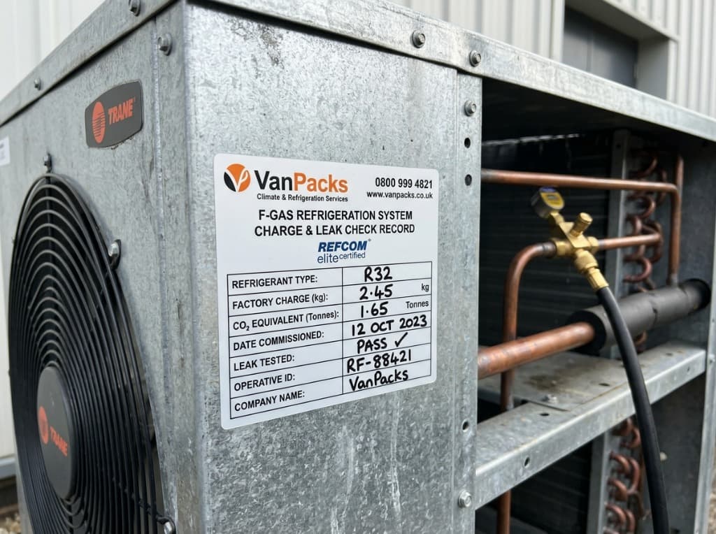 VanPacks F-Gas refrigeration charge record sticker on galvanized metal chassis of Trane commercial unit